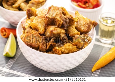 Crackling bowl, Brazilian appetizer made by frying bacon, leather or meat and lots of fat, taken from the pork belly. Royalty-Free Stock Photo #2173210131