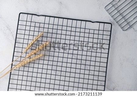 three stalks of wheat on grill wire on abstract background Royalty-Free Stock Photo #2173211139