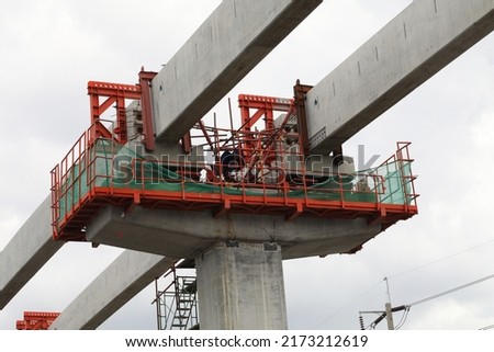 Construction of a mass rail transit line in progress. Construction site with cranes. Steel frame structure, structural steel beam. construction machinery. Royalty-Free Stock Photo #2173212619