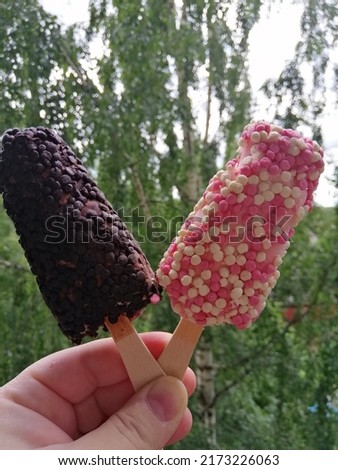 unusual ice cream in your hand against a background of green trees. summer vacation and a delicious dessert postcard