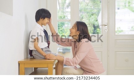Portrait of happy smiling Asian Family talking together. A student prepaing to go to school at home or house  in family relationship. Love of mother, and son. People lifestyle.