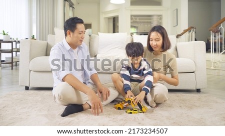 Portrait of happy smiling Asian Family. A student playing car toys at home or house in family relationship. Love of father, mother, and son. People lifestyle. Education activity.