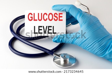 Card with GLUCOSE LEVEL supplies, pills and stethoscope. Medical concept. Royalty-Free Stock Photo #2173234645
