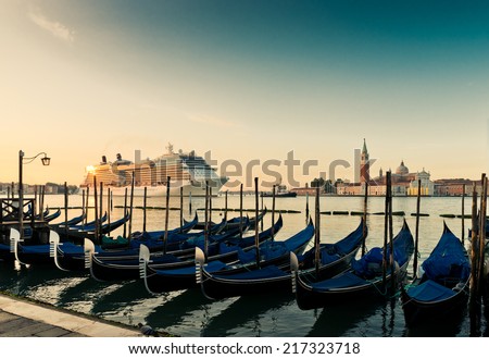 Gondolas on the background of the huge cruise ship in Venice's Grand Canal.