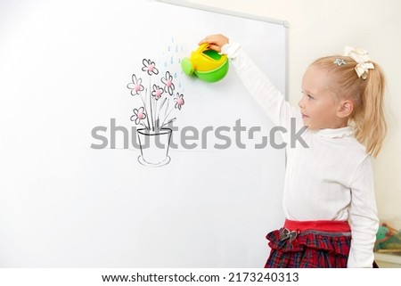 Girl watering flower drawing on a white board