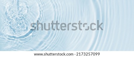close-up of a rippled water surface from above, sunshine on water jet and flowing waves and circles, fresh abstract water background concept for drinking water, spa, resource Royalty-Free Stock Photo #2173257099