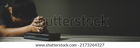 Banner image of Hands folded in prayer on a Holy Bible in church concept for faith, spirituality and religion, woman praying on holy bible.