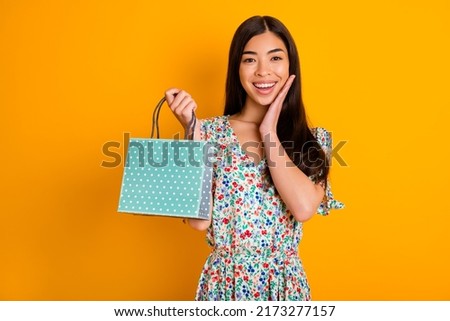 Photo of excited pretty lady hold bag arm touch cheek unbelievable offer isolated on yellow color background