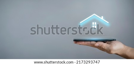 Businessman hold house icon.Smart home controlled, intelligent house, and home automation app concept.Pcb design and person with smart phone. Innovation technology internet Network Concept Royalty-Free Stock Photo #2173293747