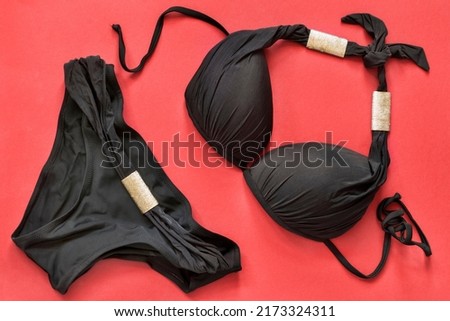 Black bikini swimming suit on red background