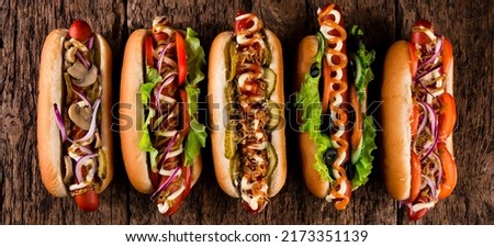 Tasty hot dogs, collection of hot dogs with various fillings on a wooden background Royalty-Free Stock Photo #2173351139
