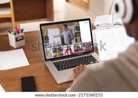 African american student studying online through video call over laptop at home. Screen, unaltered, childhood, wireless technology, education, student and e-learning concept.
