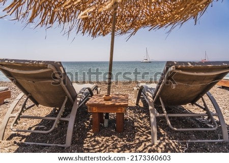 Sun loungers, parasol and beautiful blue sea.