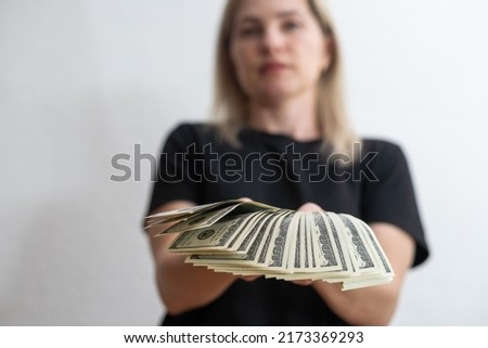 woman holding money over white wall background