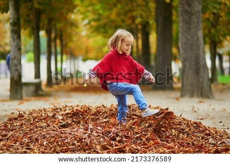Adorable preschooler girl walking in Tuileries garden in Paris, on a fall day. Happy child enjoying autumn day. Fall season in France. Outdoor autumn activities for kids
