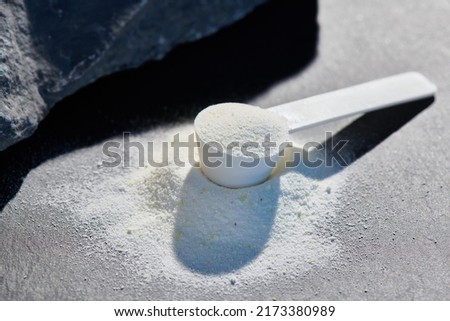 Sport food supplement powder with natural beige background and props. Supplement, creatine, hmb, bcaa, amino acid or vitamine in a white scoop. Sport nutrition concept... Check my profile for more! Royalty-Free Stock Photo #2173380989
