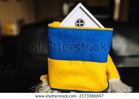Ukrainian house with national yellow-blue flag. Shelter for homeless people from Ukraine affected by the war. Conflict concept, photography.