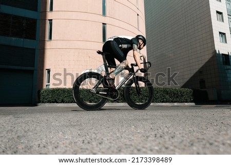 a guy on a road bike rides on the city street on asphalt
a cyclist rides down the street and the sun shines on him
sunny bike ride Royalty-Free Stock Photo #2173398489