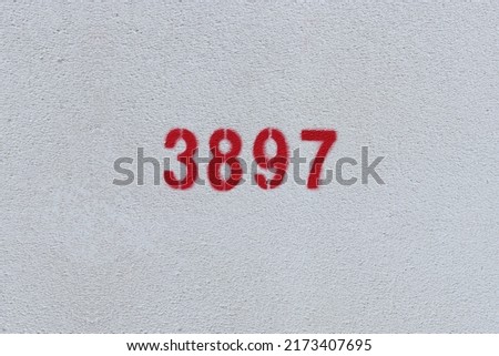 Red Number 3897 on the white wall. Spray paint.
