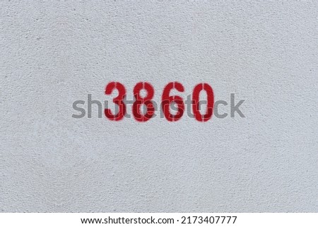 Red Number 3860 on the white wall. Spray paint.
