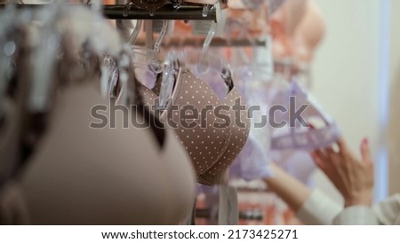 Close-up of hands choosing the size of bra cups in a department store underwear store. The concept of women's underwear for shopping.