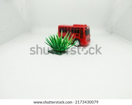 Green grass made of plastic and plastic red bus toys