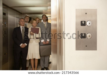 Five business executives in an elevator
