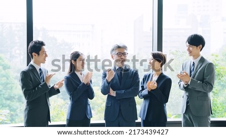 Group of businessperson standing in the office. Fist pump. Royalty-Free Stock Photo #2173439427