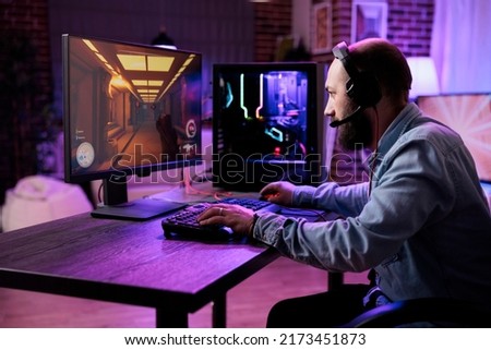 Male gamer focusing on online video games championship, playing action game on online live stream. Caucasian player having fun with virtual esport gameplay tournament on computer. Royalty-Free Stock Photo #2173451873