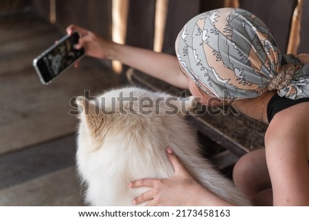 a girl takes a selfie with a dog on an excursion in a dog kennel