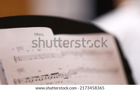 A close up view of the text or word 'Offering'. The christian hymn Offering musical score or sheet music with notes for the choir or musicians.  Royalty-Free Stock Photo #2173458365