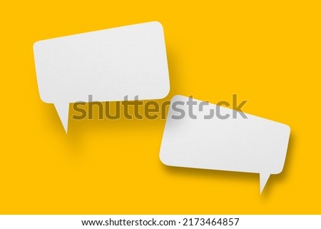 White paper in speech bubble shape set against yellow background.Communication bubbles. Royalty-Free Stock Photo #2173464857