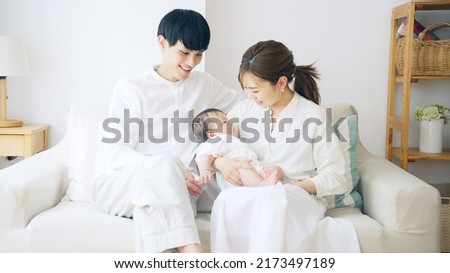 Young Asian couple with a baby. Child rearing. Childcare. Royalty-Free Stock Photo #2173497189