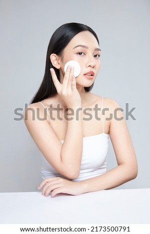 Attractive young Asian woman smile and uses cotton pad with toner for cleaning make up feeling so fresh and clean with healthy skin, isolated on white background. Royalty-Free Stock Photo #2173500791