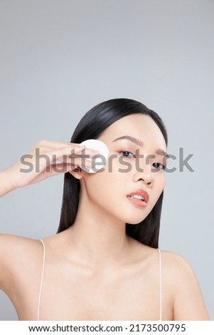 Attractive young Asian woman smile and uses cotton pad with toner for cleaning make up feeling so fresh and clean with healthy skin, isolated on white background. Royalty-Free Stock Photo #2173500795