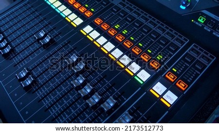 Professional tool sound engineer in the studio or at a concert. Musical digital mixer to adjust the scene close-up. The hands of man. Music and live sound. tv production