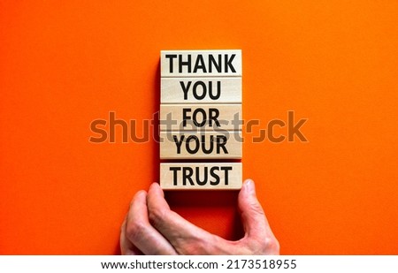 Thank you for trust symbol. Concept words Thank you for your trust on wooden blocks on a beautiful orange table orange background. Businessman hand. Business and thank you for trust concept.
