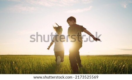 boy girl and dog a running in the park. happy family kid dream holiday concept. children hold hands brother sister run across the field silhouette summer in the park. kids run sun Royalty-Free Stock Photo #2173525569