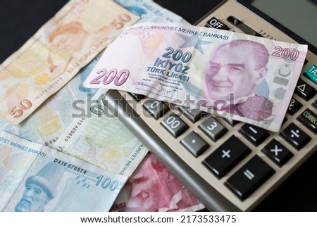 Turkish Liras and calculator on black background. Royalty-Free Stock Photo #2173533475