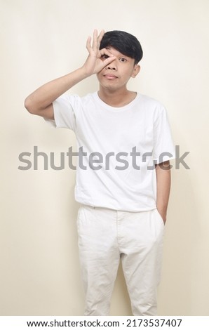 Funny obvious looking Asian man in white t-shirt on isolated background
