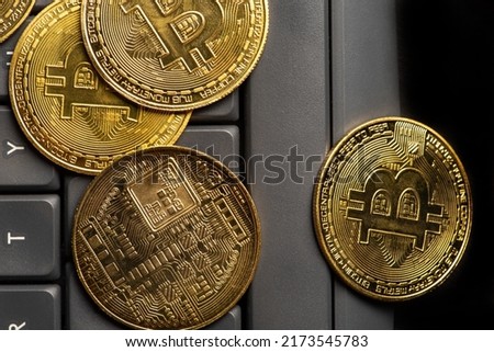 Bitcoin, bitcoin coins with a computer keyboard and mouse placed on a dark background, top view.
