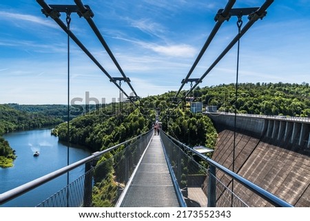 Titan RT rope suspension bridge over the Rappbodetalsperre (rappbode dam) in the Harz Mountains in Germany. In 2017, it held the record as longest suspension bridge of this type in the world. Royalty-Free Stock Photo #2173552343