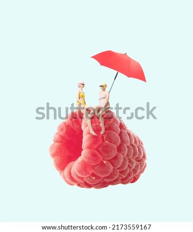 Contemporary art collage. Two girls in swimming suit sitting on raspberry under beach umbrella isolated over blue background. Concept of summer, mood, creativity, party, fun. Copy space for ad, poster Royalty-Free Stock Photo #2173559167