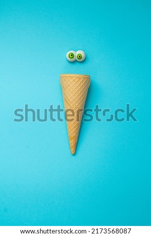 Ice cream cone with eyes. Abstract summer idea. Blue background. Copy space. 