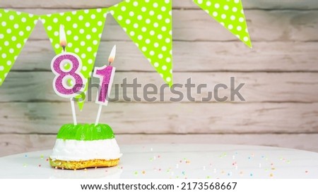Beautiful festive background with the number 81 with a cake and lit candles, space saving for any holiday. Garland with birthday decorations for a postcard.Decorations are multi-colored festive