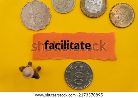 facilitate.The word is written on a slip of paper,on colored background. professional terms of finance, business words, economic phrases. concept of economy.