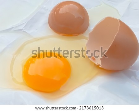 Cracked chicken eggs and egg shells on a white background