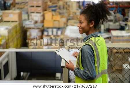 Female warehouse worker Counting items in an industrial warehouse on the factory's mezzanine floor. which is a storage for small and light electronic parts. Royalty-Free Stock Photo #2173637219