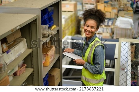 Female warehouse worker Counting items in an industrial warehouse on the factory's mezzanine floor. which is a storage for small and light electronic parts. Royalty-Free Stock Photo #2173637221