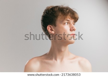 Neck and shoulders. Closeup young man, teen isolated on grey studio background. Concept of teenage skin care, health, cosmetics for problem skin, youth. Art, fashion, healthy lifestyle and ad Royalty-Free Stock Photo #2173638053